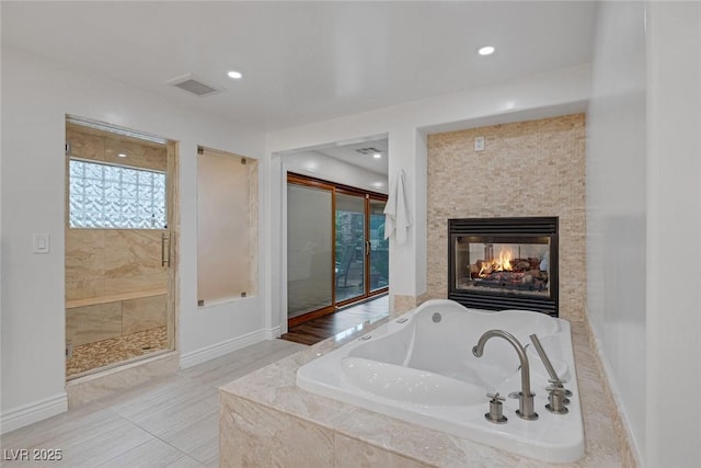 bathroom with a stone fireplace and shower with separate bathtub