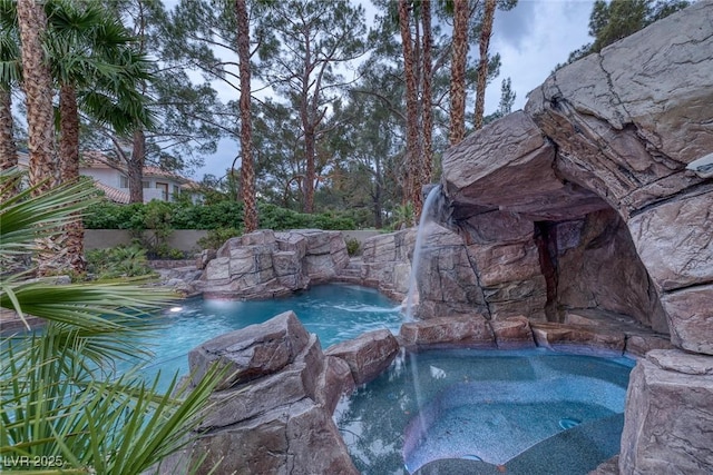 view of pool with an in ground hot tub and pool water feature