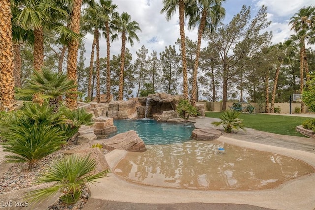 view of swimming pool with pool water feature and a yard