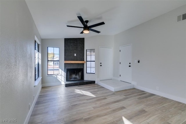 unfurnished living room with ceiling fan, light hardwood / wood-style floors, and a fireplace