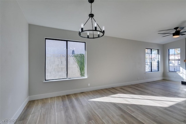 unfurnished dining area with light hardwood / wood-style floors and ceiling fan with notable chandelier