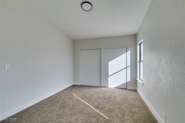 unfurnished bedroom featuring carpet floors and a closet