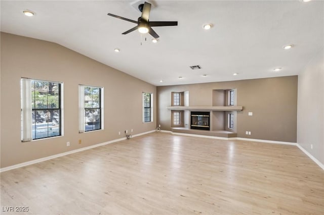 unfurnished living room with vaulted ceiling, light wood-type flooring, and ceiling fan