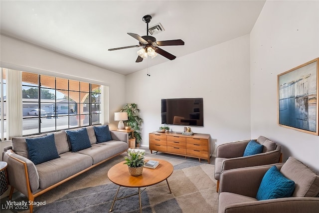 living room featuring lofted ceiling, ceiling fan, and light carpet