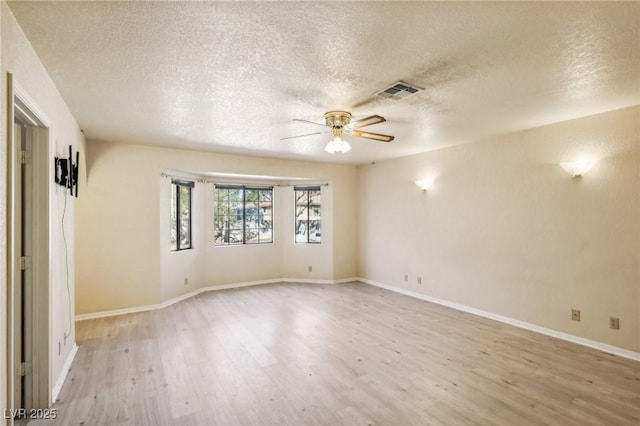 spare room featuring a textured ceiling, ceiling fan, and light hardwood / wood-style flooring