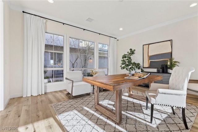 dining space with light hardwood / wood-style flooring and ornamental molding