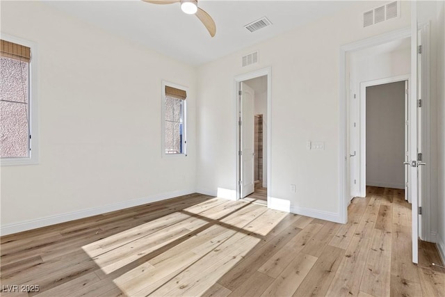 empty room with ceiling fan and light hardwood / wood-style flooring