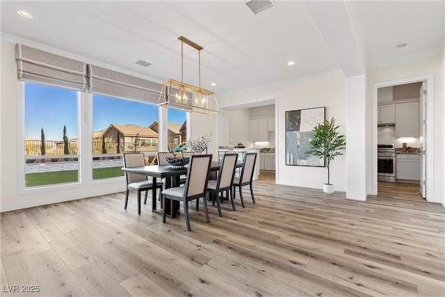 dining area featuring light hardwood / wood-style floors, a healthy amount of sunlight, and ornamental molding