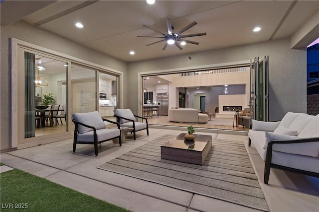 view of patio featuring an outdoor living space with a fireplace and ceiling fan