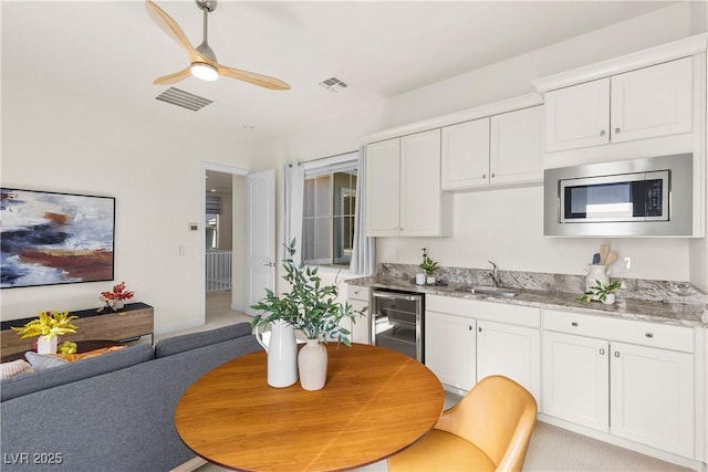 kitchen featuring light stone countertops, white cabinetry, sink, and appliances with stainless steel finishes