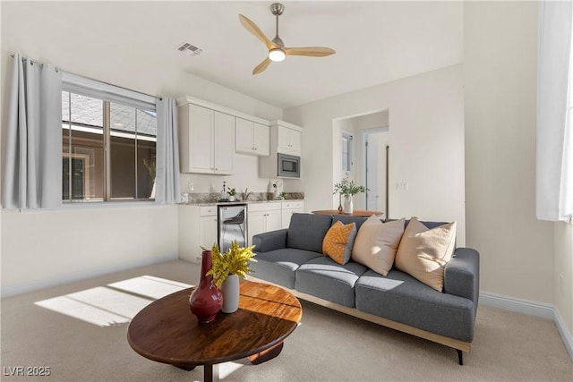 carpeted living room featuring ceiling fan