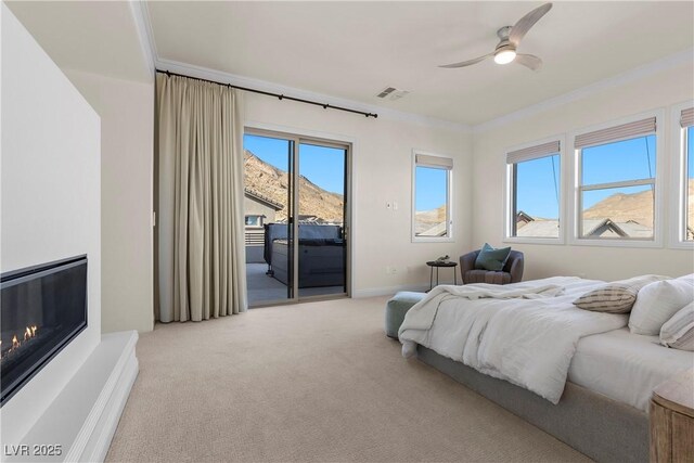 bedroom with access to exterior, carpet, ornamental molding, ceiling fan, and a mountain view