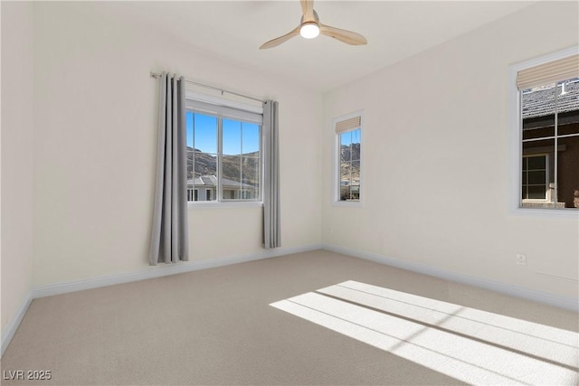 carpeted spare room featuring ceiling fan