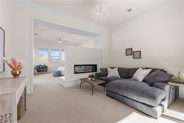 carpeted living room featuring ceiling fan with notable chandelier and crown molding