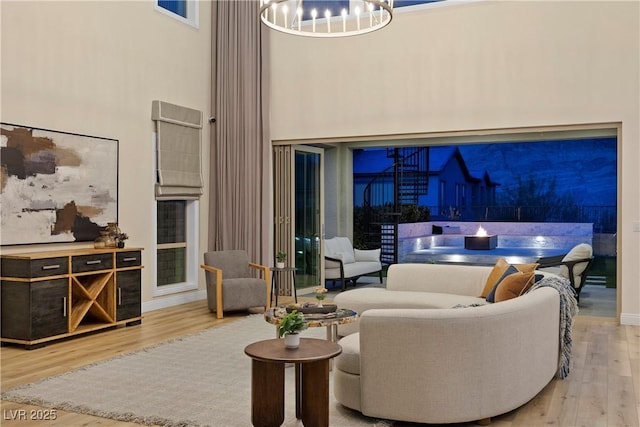 interior space featuring a chandelier, wood-type flooring, and a towering ceiling