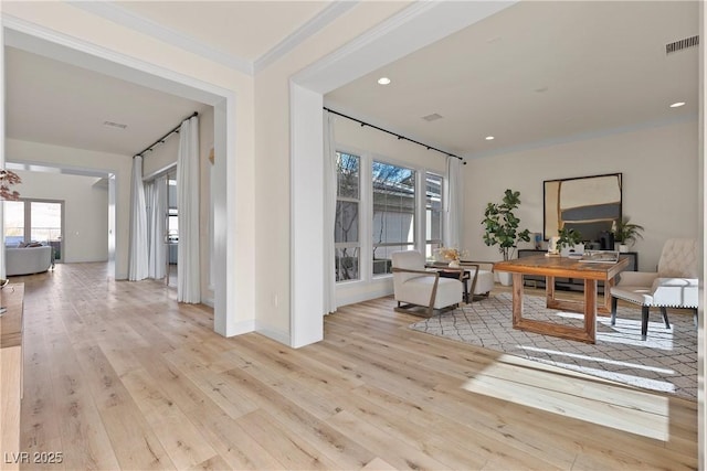 dining room featuring plenty of natural light, ornamental molding, and light wood-type flooring