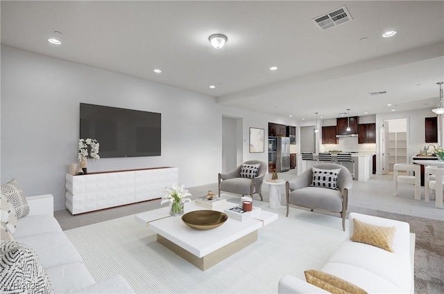 living room featuring recessed lighting, visible vents, and light carpet