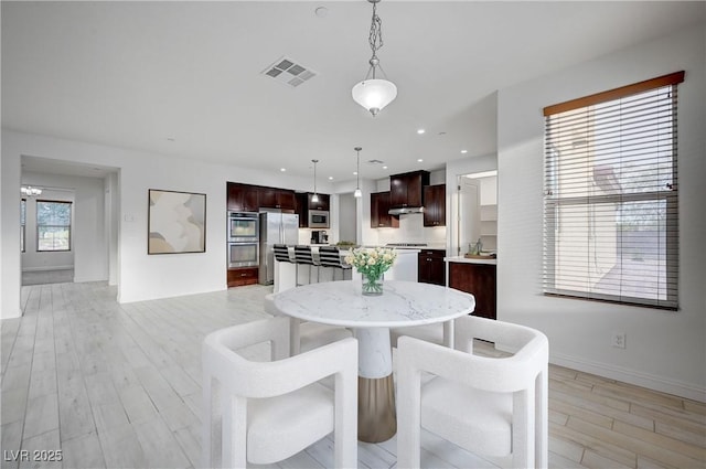 dining area featuring light wood-style flooring, recessed lighting, visible vents, and baseboards