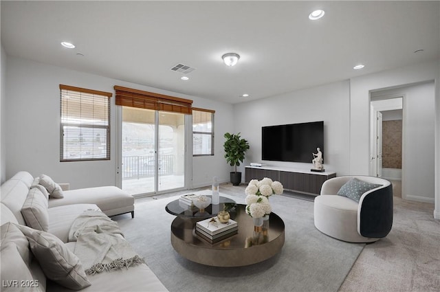 living area with light carpet, visible vents, recessed lighting, and baseboards