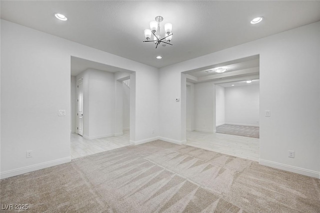 spare room with recessed lighting, baseboards, carpet, and a chandelier