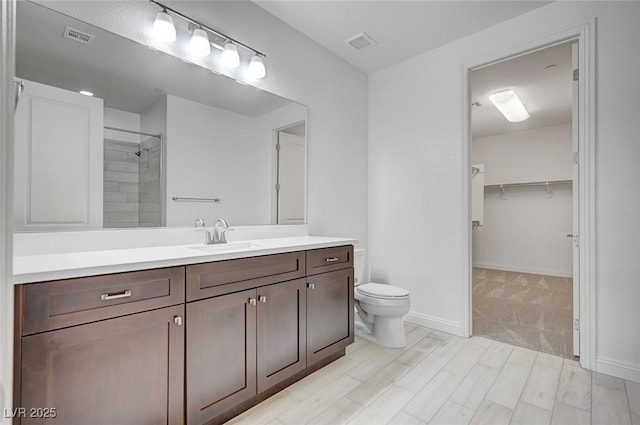 full bath featuring a spacious closet, visible vents, toilet, and vanity