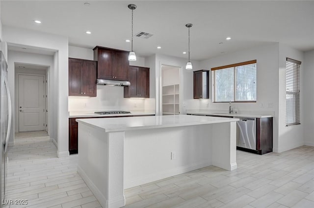 kitchen with stainless steel dishwasher, light countertops, visible vents, and a sink