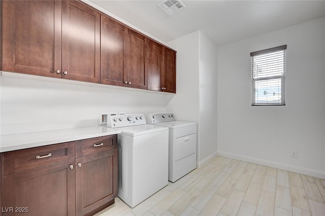 laundry room with visible vents, cabinet space, baseboards, and washing machine and clothes dryer