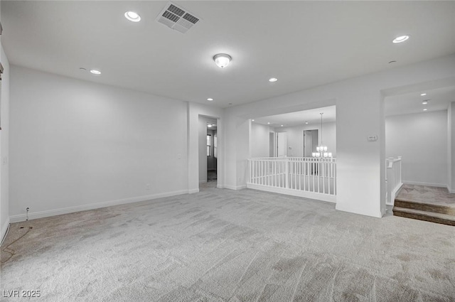 spare room featuring visible vents, carpet floors, baseboards, recessed lighting, and a notable chandelier