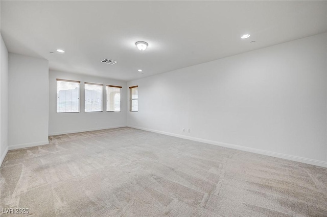 carpeted spare room with recessed lighting, baseboards, and visible vents