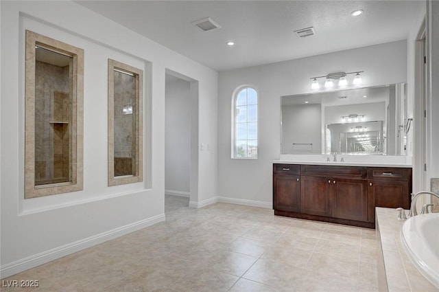 full bathroom featuring vanity, a bath, baseboards, and visible vents