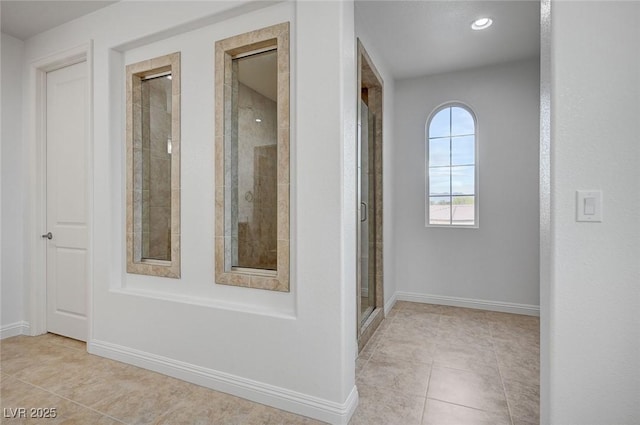 corridor featuring tile patterned flooring and baseboards