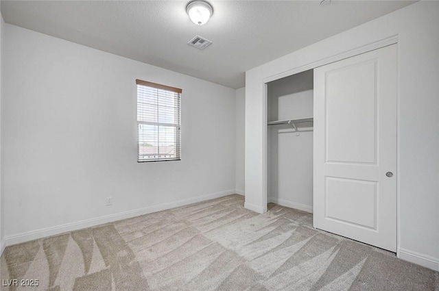 unfurnished bedroom featuring a closet, visible vents, baseboards, and carpet floors