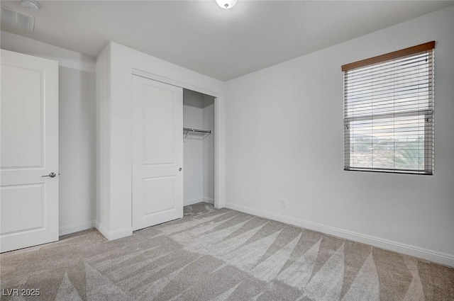 unfurnished bedroom with carpet flooring, baseboards, visible vents, and a closet