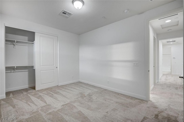 unfurnished bedroom with a closet, visible vents, baseboards, and carpet