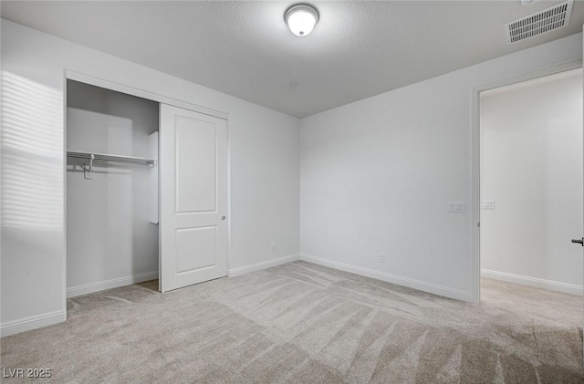 unfurnished bedroom with a closet, visible vents, baseboards, and carpet floors