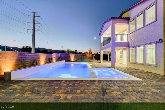 view of swimming pool with a patio, a fenced backyard, and a pool with connected hot tub