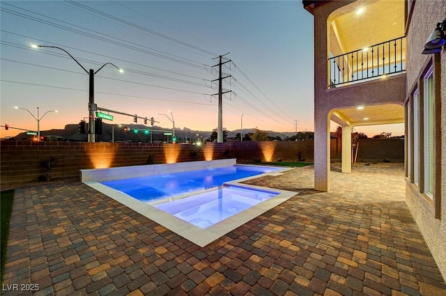 pool at dusk featuring a fenced in pool, a patio, and a fenced backyard