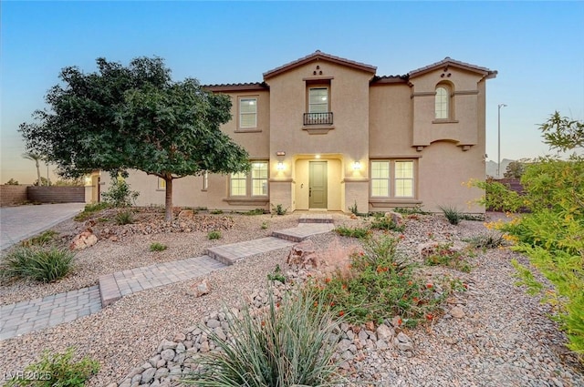 mediterranean / spanish home with a tiled roof and stucco siding