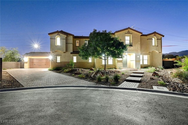 view of front of property with stucco siding, decorative driveway, and a garage