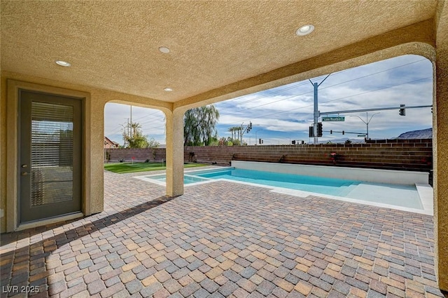 view of swimming pool featuring a pool with connected hot tub, a fenced backyard, and a patio area