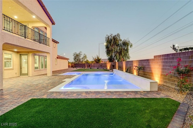 view of pool featuring a lawn, a patio, and a fenced backyard