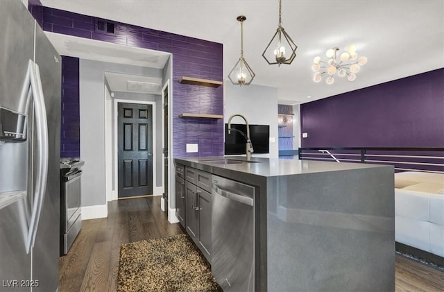 kitchen with sink, decorative light fixtures, dark hardwood / wood-style flooring, a kitchen island, and stainless steel appliances