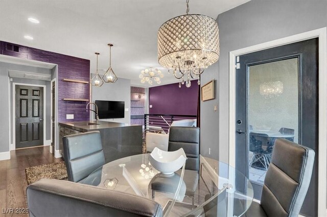 dining area with an inviting chandelier, sink, and dark hardwood / wood-style flooring