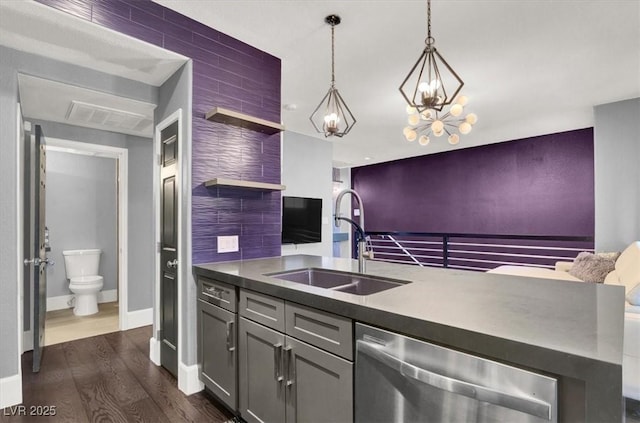 kitchen with gray cabinets, dark hardwood / wood-style floors, pendant lighting, dishwasher, and sink