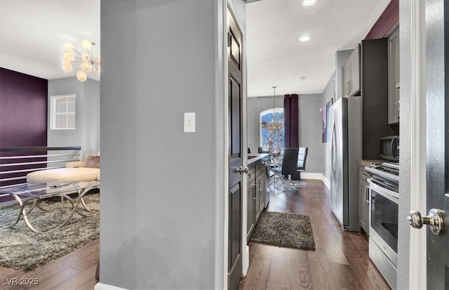 hallway featuring dark hardwood / wood-style flooring and a notable chandelier