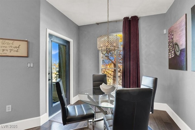 dining area featuring dark hardwood / wood-style floors and an inviting chandelier