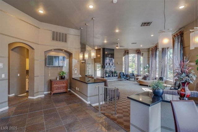 kitchen with a towering ceiling, decorative light fixtures, and a fireplace