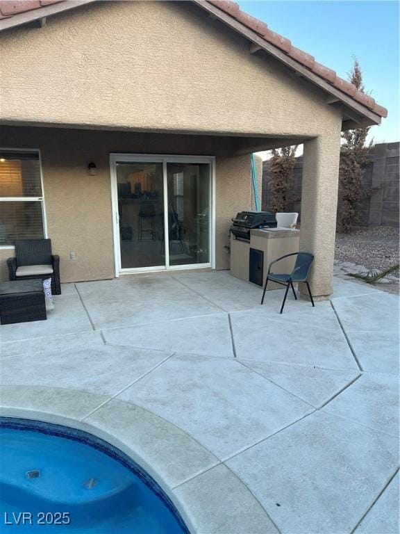 rear view of house featuring area for grilling and a patio