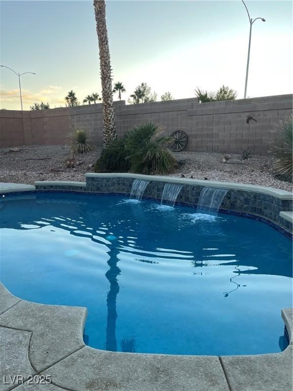 pool at dusk with pool water feature