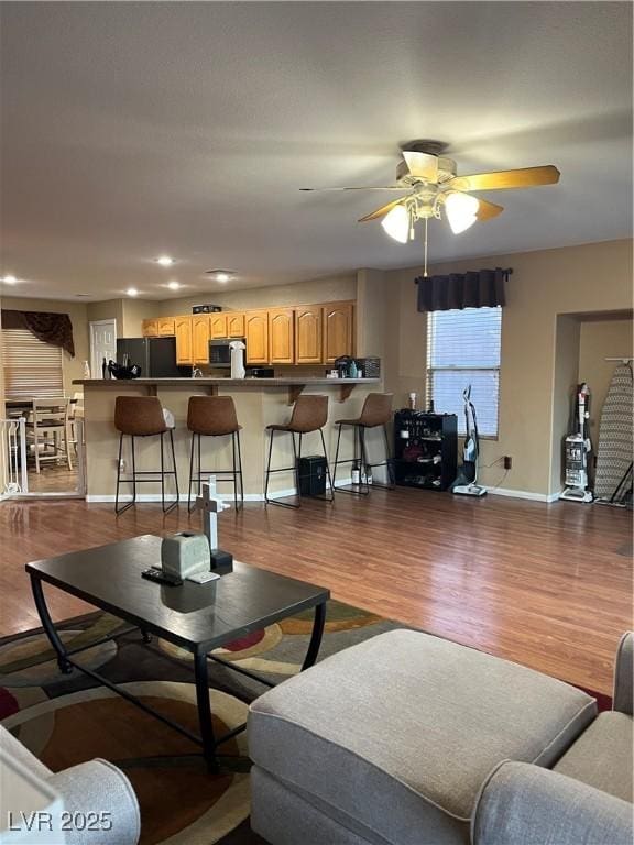 living room featuring dark wood-type flooring and ceiling fan